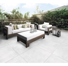 Terrasse mit Sitzgruppe und Bodenfliesen im Außenbereich.