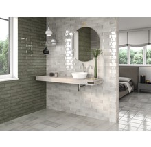 Helles Badezimmer mit Fliesen in Steinoptik, Waschbecken und Spiegel