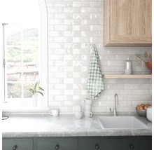 Küchenszene mit Spüle, Fliesenwand und Fenster