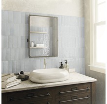 Badezimmer mit Waschbecken, Spiegel und Fliesen