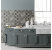 Küchenszene mit Spüle, Armatur, Küchenutensilien, Geschirr und einer Wand mit quadratischer Holzoptik