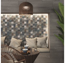 Szene mit Mosaikfliesenwand, Sitzbereich mit Kissen und Tisch mit Geschirr