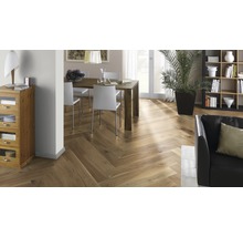 Innenraumszene mit Fischgrätparkett, Esstisch und Sitzgelegenheiten, Bücherregal und Zimmerpflanze