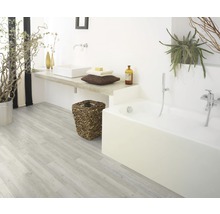Badezimmer mit Badewanne, Waschbecken, Holzboden und Pflanzen