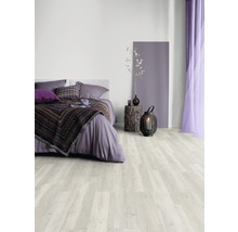 Schlafzimmer mit hellem Holzboden, Bett, Nachttisch und Dekorationen.