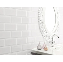 Badezimmer mit weißen Fliesen im U-Bahn-Stil, Waschbecken, Armatur und Spiegel