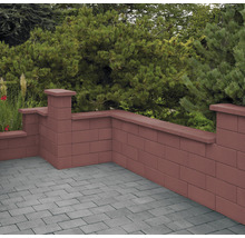 Gartenmauer aus Betonsteinen mit Abdeckung und grauer Pflasterfläche