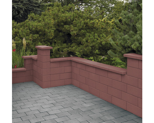 Gartenmauer aus Betonsteinen mit Abdeckung und grauer Pflasterfläche