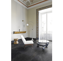 Interieur mit dunklem Boden, weißem Sessel und silberfarbenem Couchtisch