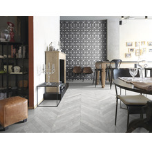 Heller Wohnraum mit grauem Fliesenboden im Fischgrätmuster, Esstisch und Dekorationen