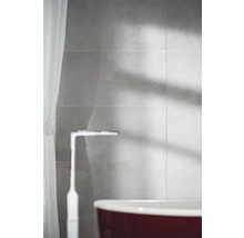 Badezimmer mit grauen Fliesen, Armatur und Badewanne