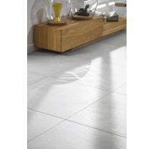 Helle, quadratische Bodenfliesen im Wohnbereich mit Holzkommode