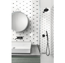 Badezimmer mit Waschbecken, Spiegel und Dusche mit geometrischen Fliesen