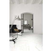 Heller Raum mit Fliesen in Marmoroptik, Sessel und Stehlampe