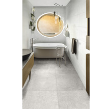 Badezimmer mit Badewanne, Spiegel, Hocker und grauen Bodenfliesen