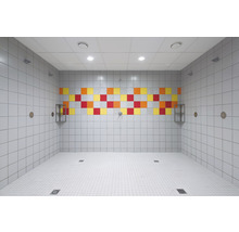 Gefliester Duschraum mit bunten Akzenten und Ablaufrinnen