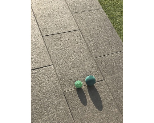 Verlegte Terrassenplatten mit zwei Spielzeugbällen