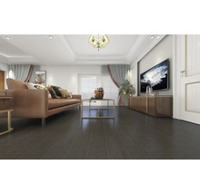 Wohnzimmer mit braunem Sofa, Couchtisch und dunklem Laminatboden.