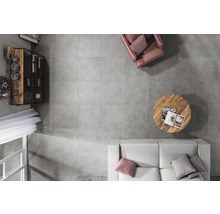 Ansicht von oben eines Wohnzimmers mit grauen Fliesen, Sofa, Sessel, Tisch und Regal