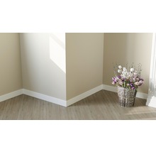 Helle Raumecke mit Laminatboden, weißen Sockelleisten und Blumenarrangement