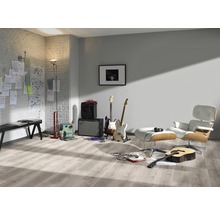 Heller Raum mit Gitarren, Verstärkern, Sessel und Laminatboden