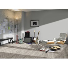 Heller Raum mit Laminatboden, Gitarren, Verstärkern und Sessel.