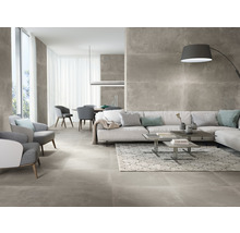 Helles Wohnzimmer mit grauen Bodenfliesen, Sofa, Sesseln und Esstisch