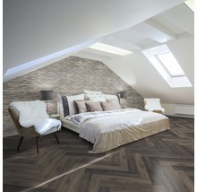 Schlafzimmer im Dachgeschoss mit schrägem Dach, Ziegelwand und Fischgrätenparkett