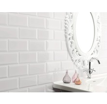 Badezimmer mit weißen Metrofliesen an der Wand, Waschbecken, Armatur und Spiegel