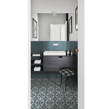 Badezimmer mit Waschtisch, Spiegel und gemustertem Boden