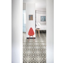 Flur mit gemusterten Bodenfliesen, Stuhl und Blick in ein Schlafzimmer