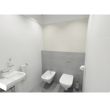 Helles Badezimmer mit Waschbecken, Bidet und Toilette vor Wandfliesen