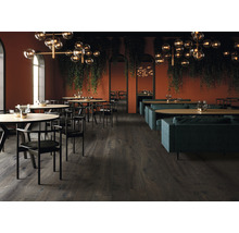 Innenaufnahme eines Restaurants mit Tischen, Stühlen, Sofas und Holzboden