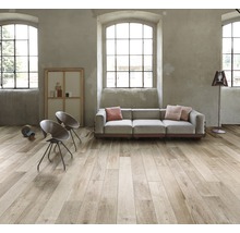 Heller Wohnraum mit Holzoptik-Fliesen, Sofa, Stühlen und Tageslicht.