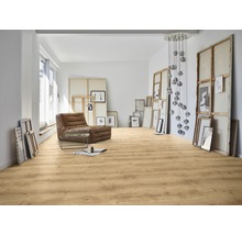 Heller Raum mit Laminatboden, Sessel und Kunstwerken.