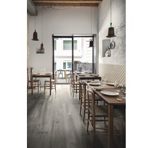 Restaurant mit Holzböden, Holztischen und Stühlen, sowie Pendelleuchten.