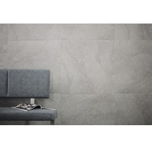 Graue Wandfliesen mit Sitzbank und Zeitschrift