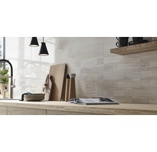 Helle, geflieste Küchenwand mit Holzarbeitsplatte und Küchenutensilien