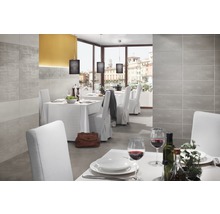 Heller Raum mit gedeckten Tischen und grauem Fliesenboden