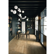 Innenraum mit Holzboden, Bücherregalen, Tisch und Beleuchtung.