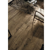 Wohnzimmer mit Boden aus Laminat in Holzoptik, Teppich, Sessel und Tisch