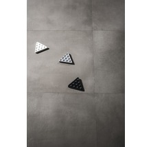 Drei dreieckige Bodenindikatoren mit Noppen auf Fliesen