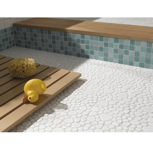 Badezimmer mit Boden aus Kieselsteinfliesen, Sitzbank mit Mosaikfliesen und Holzrost mit Badeschwamm und Quietscheente