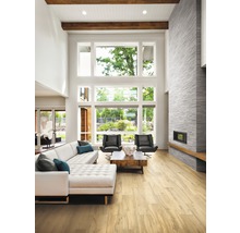 Heller Wohnraum mit Sofa, Sesseln, Kamin und großem Fenster