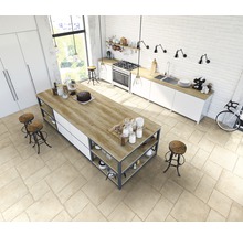 Helle Küche mit Kochinsel, Stühlen und Küchengeräten in einem geräumigen Raum.