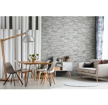 Wohnzimmer mit Esstisch, Stühlen, Stehlampe und Wandverkleidung in Steinoptik