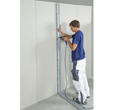 Mann montiert eine Gipskartonwand mit einem Akkuschrauber.