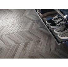 Graue Fliesen in Fischgrätmuster mit Schuhen im Regal