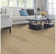 Wohnzimmer mit hellem Holzboden, Sofa, Sessel und Tisch