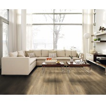 Heller Wohnraum mit Laminatboden, Ecksofa und großen Fenstern